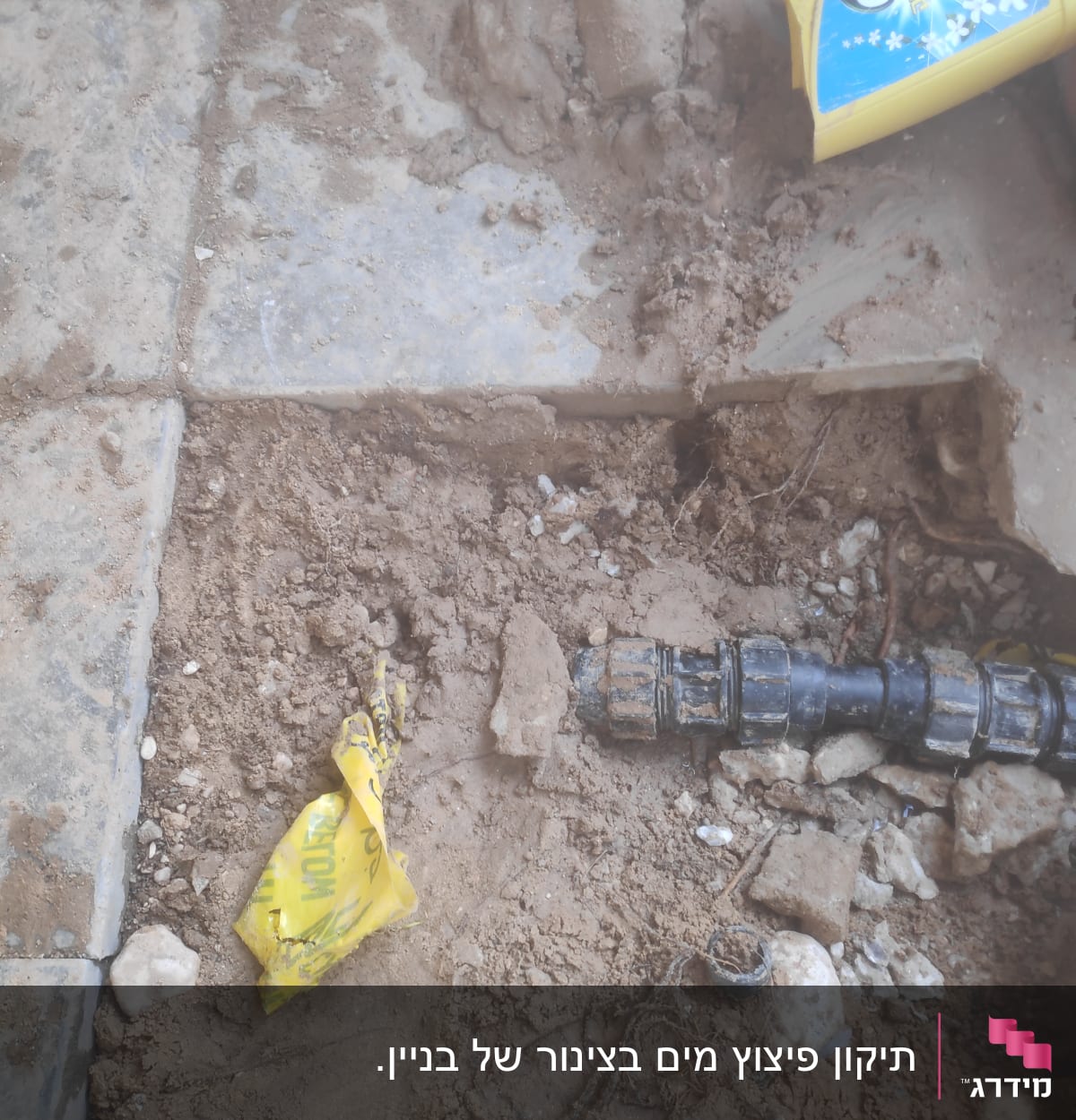צינור שחור עם מחבר על אדמה חשופה